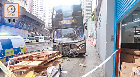 九巴撞毀鐵欄後衝上行人路。（曾紹良攝）