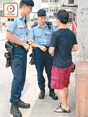 警員在邨內截查男街坊。（李健瑜攝）