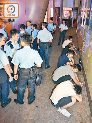 警方要求五名男子蹲在地上協助調查。（梁國雄攝）