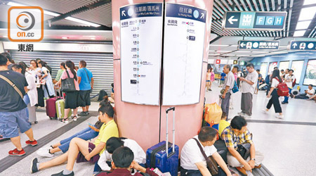 九龍塘<br>懸掛九號及十號風球期間，港鐵一度暫停所有地面和架空路段列車，有乘客惟有席地而坐，等候列車重開。