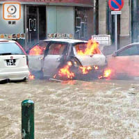 大潮湧浪令馬路短時間變澤國，路旁有汽車起火。