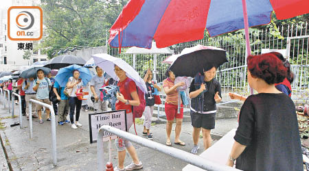 不少家長帶備摺櫈、枕頭、雨傘到男拔的附屬小學排隊，望取得學校簡介會入場券。