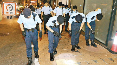 警員晚上在行人路作地氈式搜索。（梁裔楠攝）