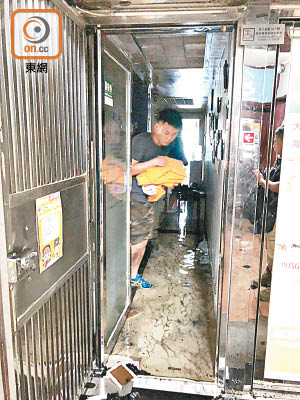 中醫館內有積水，職員忙於清理。（左錦鴻攝）