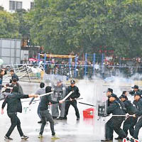 參演警員在演練中手持盾牌，與持刀的「暴恐分子」對峙。（互聯網圖片）