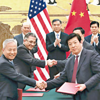 中美企業在汪洋（後中）與羅斯（後左）見證下簽署合作協議。