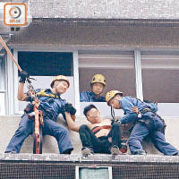 企跳男子由消防員協助爬入屋內。（曾紹良攝）