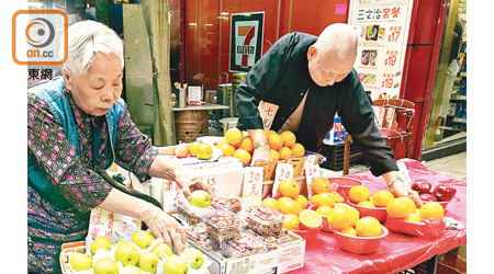 盧婆婆（左）在中環賣水果長達七十年，最近想申領固定小販牌照，期望可以繼續經營下去。旁為丈夫周伯伯。（黎忞攝）