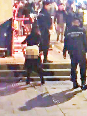 蘭桂坊一名金啡色長髮、穿黑色短裙的醉娃在警員面前隨地便溺。（互聯網圖片）