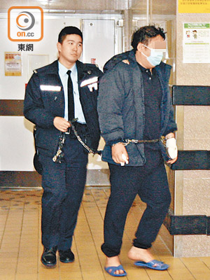 腰纏鐵鏈及戴上手銬的男被告KIM Minho，昨晨由警員押送離開病房前往法庭應訊。（吳建明攝）