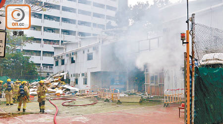 起火地盤辦公室冒濃煙，消防員到場灌救。（曾志恆攝）