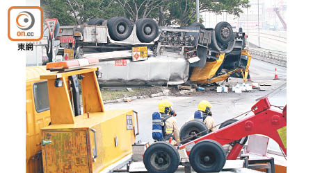 肇事運油車失事翻轉，消防員在場戒備。（馮溢華攝）