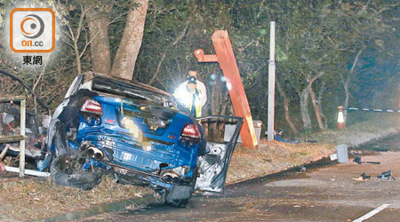 跑車嚴重焚毀，警員在場調查。