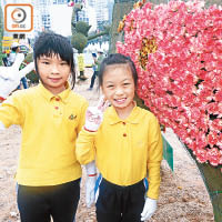 黃同學（左）和謝同學（右）獲義工指導，知道按摩花朵可令花兒開得更燦爛。