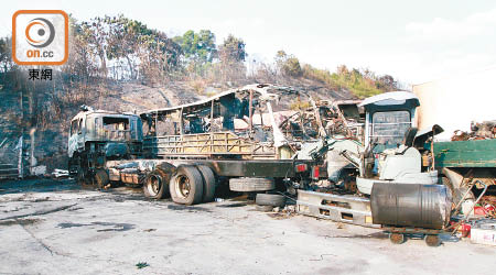 車場被山火波及，多輛貨車被燒成廢鐵，負責人周先生面對損失慘重，欲哭無淚。（李子強攝）