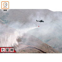 直升機在元朗投擲水彈撲山火。（黃子喬攝）