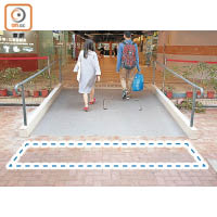 由於華明邨法團反對，導致商場新建無障礙斜道未能裝設盲人引路徑延伸到商場外（虛線示）。