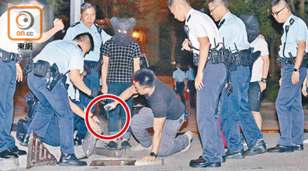 警員押同被捕兩男子在坑渠檢走一把利刀（紅圈示）。（陳家富攝）