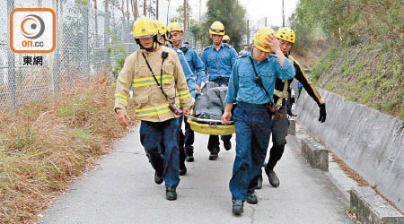 消防員將死者遺體抬回行人道。（胡德威攝）