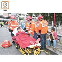救護員將受傷小巴乘客送院。