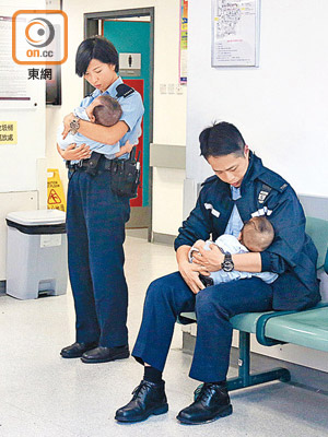 孖仔由男女警員抱着在醫院等候檢驗。（趙瑞麟攝）