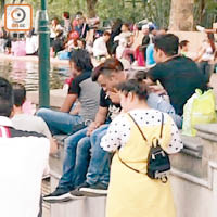 圍觀的南亞人在旁不停吸煙，懶理公園禁煙規定。