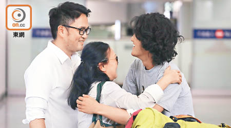 陳家希（右）昨返港，其兄長（左）及媽媽（中）到機場迎接他，三人一見面互相擁抱。