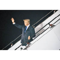 美國總統特朗普步出機艙，向在場人士揮手。（美聯社圖片）