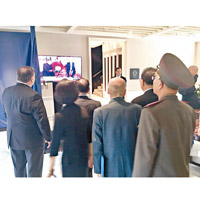美朝隨行人員圍在一起看電視直播特金會。（互聯網圖片）