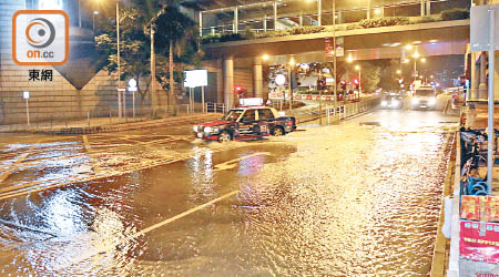 中環爆水管水淹街道，車輛需要慢駛。（吳建明攝）