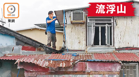 村民吳先生爬上屋頂將其鐵皮屋「五花大綁」。（朱先儒攝）