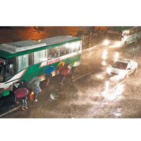 馬尼拉有民眾冒着暴雨前行。（美聯社圖片）