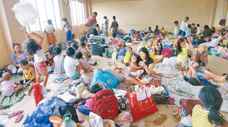 大批菲律賓民眾到避難所暫避。（美聯社圖片）