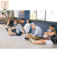 多名乘客因等候太久，坐在車站大堂歇息。