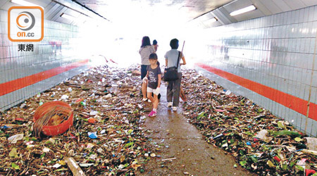 大埔<br>大埔一條行人隧道曾水浸沒頂，風災過後，小朋友及市民協助清理樹枝及垃圾。（余宏基攝）
