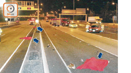 三名旅巴乘客被拋出車外身亡，救護員用紅氈遮蓋遺體（箭嘴示）。（沈厚錚攝）