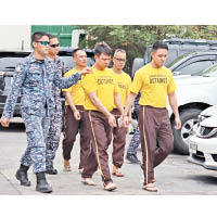 身穿黃色囚衣的四名被告被押解至法院。（互聯網圖片）