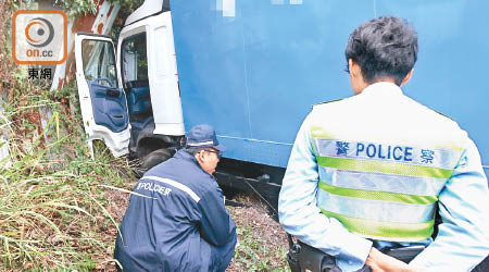 涉事貨車衝前撞向圍欄，警員在場調查。（文健雄攝）