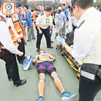 一名男跑手在終點不適倒地，由救護人員急救。（袁志豪攝）