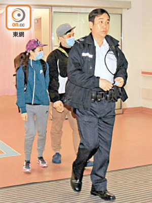女嬰父母隨警員往警署助查。（張開裕攝）
