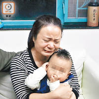 遺孀抱着幼子，哭訴要求查明意外真相。（文健雄攝）