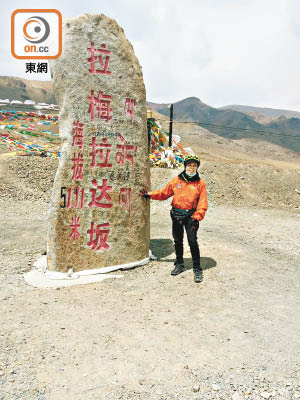 錢志標上年曾踩單車遊西藏亞里，於海拔高達五千一百多米的拉梅拉達坂前留影。（受訪者提供）