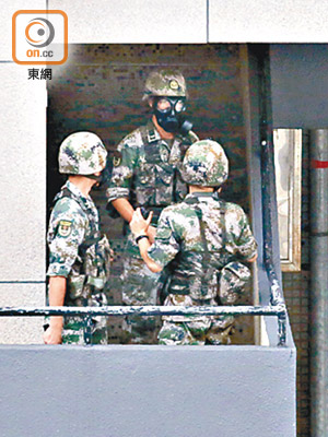 解放軍駐港部隊軍營內軍人戴上防毒面罩。（黃偉邦攝）