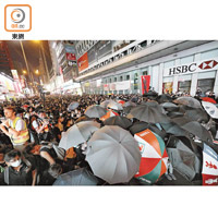 大批示威者晚上在彌敦道撐起雨傘，與警方對峙。（黃仲民攝）