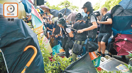 昨日光復上水遊行中，大批示威者圍堵四名警員，期間用雨傘不斷攻擊警員。（高嘉業攝）