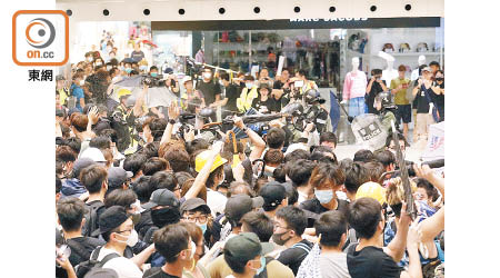 示威者包圍警方及不斷投擲硬物。