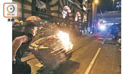 上環：示威者把點燃雜物的手推車推向警方防線。（陳章存攝）