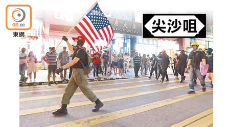 有示威者在遊行期間高舉美國旗。
