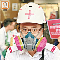 一名男護士戴上防毒面具及頭盔參加集會。