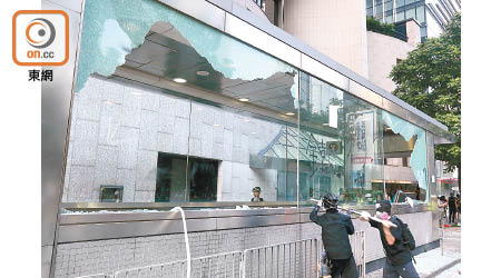 示威者用鐵枝等硬物擊碎中環站出入口的巨型玻璃。